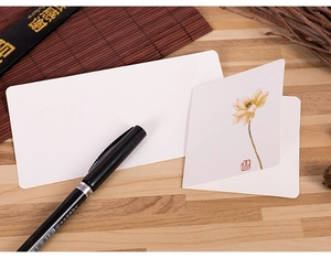 Detail of Chinese style greeting card with yellow lotus ink painting and white envelope