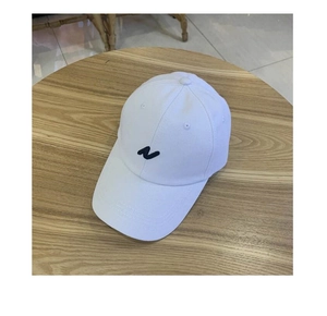 Détail d'une casquette en coton avec broderie de la lettre N sur table en bois