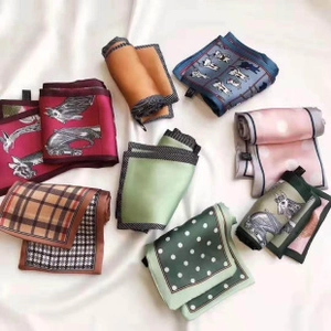 Flat lay detail showing assorted 70x70 printed silk squares with polka dot and horse patterns