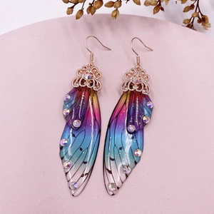 Detail of gradient cicada wing earrings with rhinestones and golden hooks
