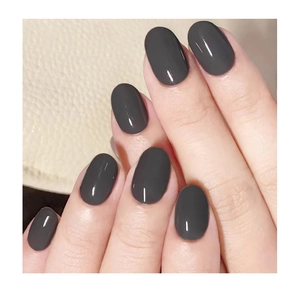 Macro shot of oval glossy dark grey nail tips with a smooth mirror finish