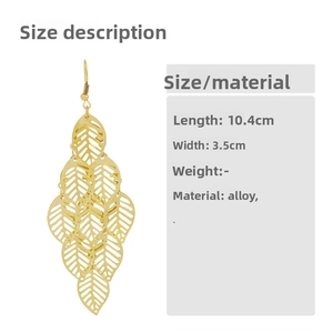 Detailed view of long tiered hollow leaf tassel earrings in shiny gold finish
