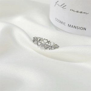 Detailed macro view of hollow heart ring with sparkling zircons on white silk