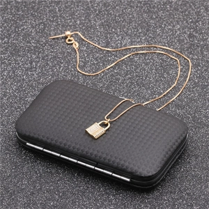 Close-up of gold key lock pendant with zircons on a carbon fiber texture box