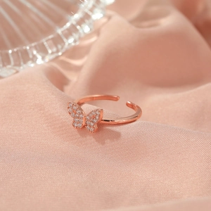 Elegant rose gold butterfly open ring with sparkling pavé crystals on satin fabric