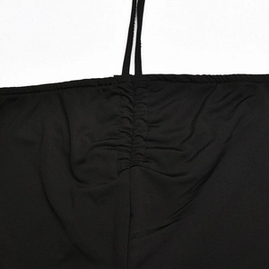 Close-up of black elastic jumpsuit with deep V-neck ruched detail and spaghetti strap