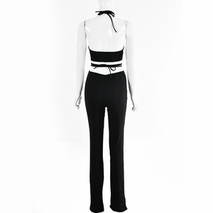 Back view of black halter crop top and matching slim trousers on a white mannequin