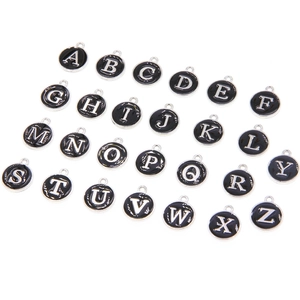 Close-up of A-Z double-sided enamel letter pendants in black with silver frames