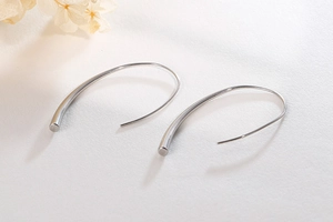 Macro detail of silver minimalist teardrop hook earrings with polished finish