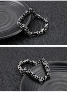 Close-up of industrial stainless steel king chain bracelet with lobster clasp on black background