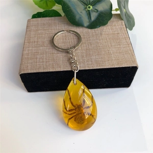 Detailed close-up of a spider specimen inside a teardrop amber resin keychain