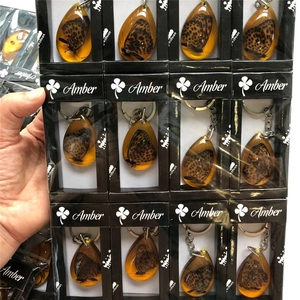 Teardrop resin keychain with real butterfly specimen inside packaged in a black window gift box