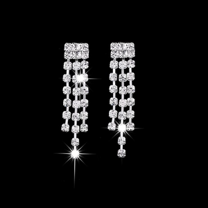 Silver bridal jewelry set with long tassel rhinestone earrings on a dark background