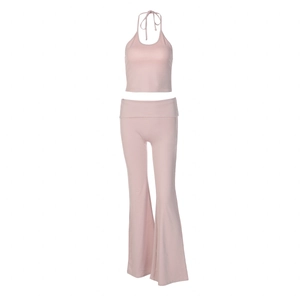 Macro detail of high-waist yoga set with halter crop top and flared trousers in soft pink