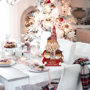 Close-up of plush Christmas figurines with Merry Christmas sign on a festive table