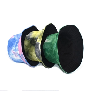 Three tie-dye corduroy bucket hats in blue, yellow, and green colors for women