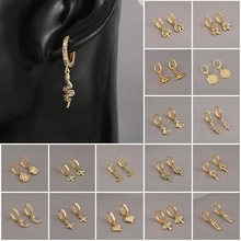 Detailed grid of gold star and moon huggie hoop earrings with zircon charms
