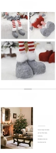 Detail showing the red striped knitted legs and gray felt boots of the Christmas gnome