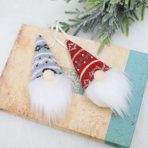 Christmas knitted gnome ornaments in red and gray on vintage books with pine branches