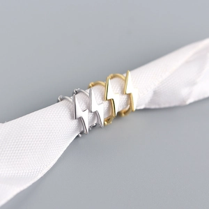 Dettaglio di mini orecchini a cerchio a forma di fulmine in argento e oro