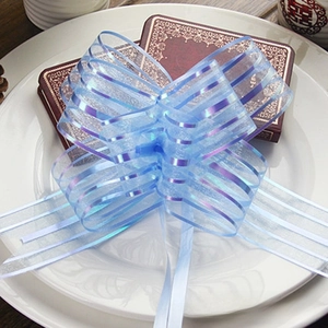 Close-up of light blue organza pull bow with purple iridescent stripes on gift box