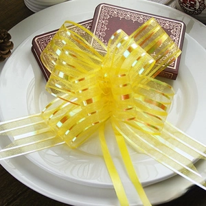 Detailed view of yellow organza bow with gold stripes on white ceramic plate