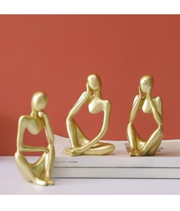Three golden abstract thinker sculptures on white books against red and white background