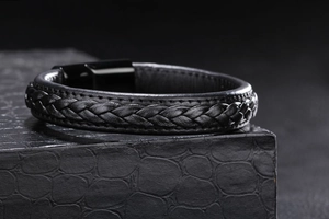 Gros plan sur bracelet en cuir tressé noir avec fermoir magnétique en métal poli