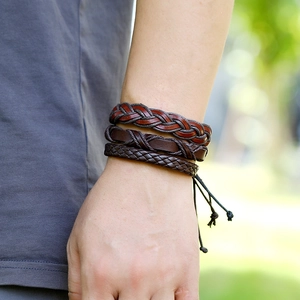 Detail of vintage multilayer brown leather bracelets set on a male wrist in nature