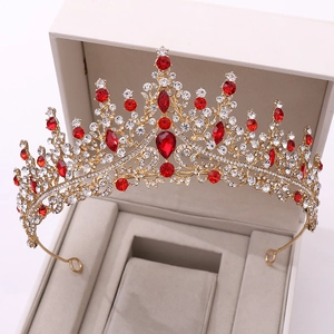 Luxurious gold bridal crown with red gemstones and crystals in a jewelry box