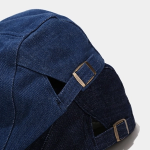 Close-up of the back of a washed denim cap with adjustable double metal buckles