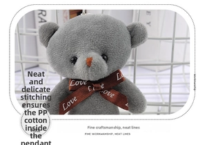 Detailed macro view of gray plush teddy bear keychain featuring a Love printed ribbon