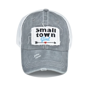 Detail of grey washed cotton trucker hat with Small Town Girl patch and white mesh