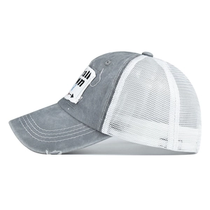 Close-up of distressed grey baseball cap with small town patch and white mesh back