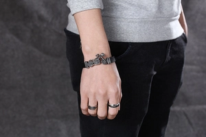 Detail of leather punk bracelet with motorcycle skull pendant and matching biker rings