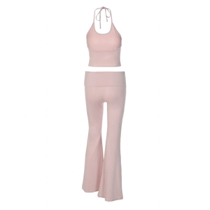 Detail of pink two-piece set featuring halter neck crop top and high waist flared trousers