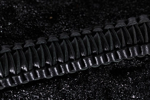 Macro detail of high-quality black braided leather strap with intricate woven texture