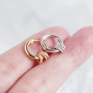 Detail of S925 sterling silver hoop earrings with zircon charms held on fingers