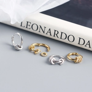 Macro detail of gold and silver S925 sterling silver hoop earrings with diamond beads