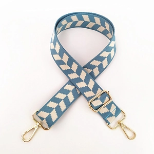 Detail of adjustable blue and white arrow pattern bag strap with gold metal hooks
