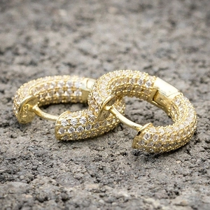 Macro shot of S925 sterling silver gold plated huggie earrings with pave cubic zirconia