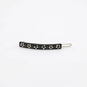 Black acetate hair clip featuring colorful rhinestone flower patterns on a white background