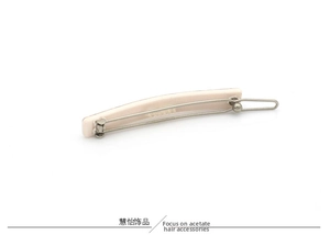 Close-up of pink and cream acetate hair clip with durable metal spring fastener mechanism