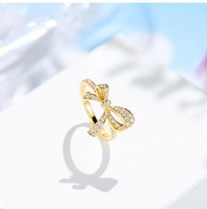 Luxurious gold bow ring with pave-set shimmering diamonds and hollow layered design