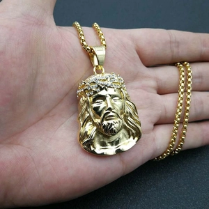 Macro shot of gold-plated Jesus pendant with rhinestones on a box chain necklace