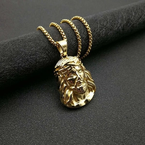 Detailed macro view of gold-plated Jesus pendant necklace with box chain on display