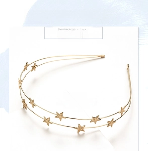 Detail of gold double-layered headband with textured star accents and minimalist design