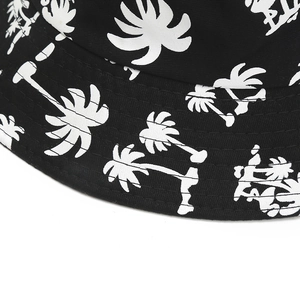 Detailed close-up of the black twill fabric and white palm tree print on the bucket hat