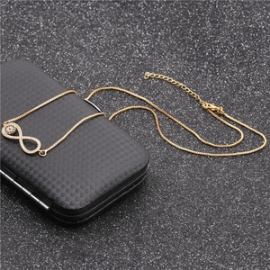 Detail of infinity devil eye gold necklace with clear and black zircons on display