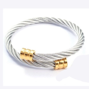 Détail d'un bracelet câble torsadé argenté avec embouts cylindriques dorés